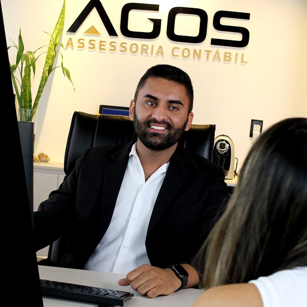 Alan Gonçalves atendendo cliente no escritório da AGOS